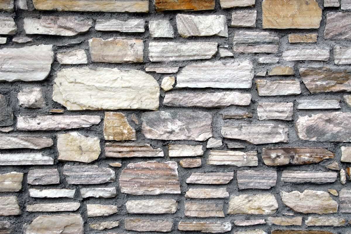 Marble stone wall with many irregular pieces fitted together.